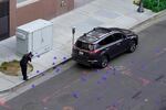 A crime scene investigator photograph evidence markers at the scene of a mass shooting In Sacramento, Calif. April 3, 2022.