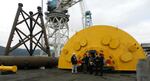 Senators Ron Wyden (Oregon) and Lisa Murkowski (Alaska) and Ocean Power Technologies VP Robert Lurie stand in front of the large float device as they discuss the company's planned wave-energy project, Reedsport OPT Wave Park.