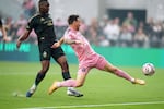 Inter Miami midfielder Leo Messi shoots past Portland Timbers defender Kamal Miller during the first half of an MLS soccer match, Sunday, May 17, 2026, in Miami.