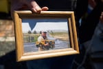 Otis Cody holds a framed photo of his father, Ray Cody, with a model truck like the ones Otis makes today in Fossil, Ore., Tuesday, June 4, 2019.