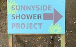 A sign in the Sunnyside neighborhood points the way to showers for people experiencing homelessness.