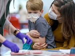 Clive James-May, 6, is comforted by his mother, Madison James, as they attend a vaccination clinic at McDaniel High School in Northeast Portland on Feb. 8, 2023. 