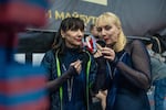 Sunrise cheerleading team members Iryna Nesterenko, 63, sports trainer (left), and Olena Zolotchenko, 57, beauty worker (right), are applying makeup before a performance in Kyiv during Ukraine Cheer Cup competition on Dec. 13, 2025.