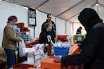 Prevention Point employees (from left) PJ Haenn, Eliza Martin-Rosenthal and Evan Harrold help participants exchange used syringes for new, sterile ones in the Kensington neighborhood of Philadelphia, Pennsylvania on Feb. 28.