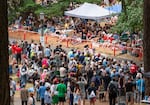 A soapbox derby team flies by a large part of the crowd.