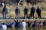 FILE - Protestors demonstrating against the expansion of the Dakota Access Pipeline wade in cold creek waters confronting local police, near Cannon Ball, N.D., Nov. 2, 2016.