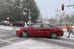 In the Sylvan Hills area of Southwest Portland, a driver receives some help getting up Barnes Road. Feb. 22, 2023.