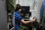 Ulysses, 14, plays with a stray cat the family adopted in their temporary home in Lviv.