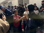 People embrace in the aftermath of the Gaza City School airstrike on May 27, 2025.