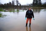 FILE - Shelley Pasco, owner of Whistling Train Farm, stands in one of the flooded fields at her farm on Thursday, Dec. 18, 2025, near the Green River in Kent, Washington.
