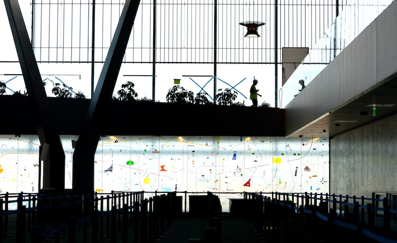 Portland artist Yoonhee Choi created two large glass walls, bottom, for each of the queuing areas near the TSA checkpoints at the Portland International Airport, Aug. 2, 2024. The walls are 56 feet long by 11 feet high.