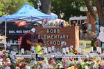 A man and a child pay their respects at a memorial to the victims of the Robb Elementary School mass shooting on May 28, 2022 in Uvalde, Texas.