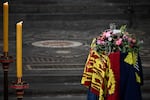 The coffin of Queen Elizabeth II, draped in the Royal Standard, lies inside Westminster Abbey.