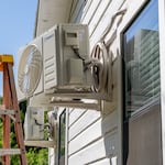 An air conditioner undergoes repair earlier this month in Austin, Texas. Record-breaking temperatures continue across large swaths of the U.S.