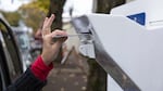 A voter drops off a ballot at a Multnomah County dropbox in November 2016.
