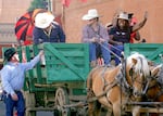 A cowboy talks with a couple of teamsters in a horse-drawn wagon as Nkenge Johnson Harmon and other members of the Urban League of Portland interact with the parade crowd.