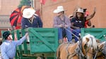 A cowboy talks with a couple of teamsters in a horse-drawn wagon as Nkenge Johnson Harmon and other members of the Urban League of Portland interact with the parade crowd.