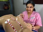 Meenakshi Gupta, who is blind, works as a "medical tactile examiner" to identify breast tumors. The mannequin is used in the training program for would-be examiners. The strips enable the examiners to identify and carefully examine each zone of the breast.