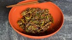 A bowl of Sichuan style dry-fried fiddlehead ferns with chile oil, garlic and scallions