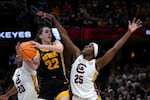 Iowa guard Caitlin Clark (22) passes over South Carolina guard Raven Johnson (25) during the first half of the Final Four college basketball championship game in the women's NCAA Tournament, Sunday, April 7, 2024, in Cleveland.