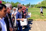 In this July 2022 file photo, backers of the initiative that would require individuals to secure permits to buy firearms and ban large-capacity magazines deliver the signatures of thousands of voters to state election offices in Salem, Ore. After the initiative passed as Measure 114, it quickly faced challenges in court.