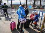A Ukrainian refugee speaks with a local interpreter as she and her two children arrive at the Siret border crossing between Romania and Ukraine on April 18.