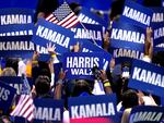 Supporters carry signs as Democratic presidential nominee Vice President Kamala Harris speaks during the Democratic National Convention on Aug. 22 in Chicago.