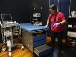 Staff member Katie Yates preps the procedure room in Arnold’s office in Richmond, Va. There’s one blue cushioned exam table where she performs abortions, skin tag and mole removal, pelvic exams, biopsies and IUD placements.