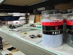 Colored frit, a raw material commonly used in glass-making, sits on a shelf at the Bullseye factory.