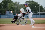 Kelsie Whitmore (right), no. 1 draft pick of the San Francisco Firebells and of the WPBL overall draft, guides veteran baseball player Maybelle Blair, 99, off the field after the first pitch ceremony on Opening Day of the WPBL. Springfield, IL, August 1, 2026.