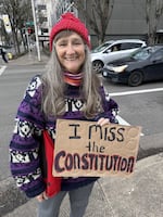 Mary Sue Backus of Eugene said she knitted 10 red hats over a two-week period ahead of the protest held on Feb. 26, 2026.