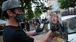 Jonathan Luczycki paints Donavan La Bella across from the Mark O. Hatfield federal courthouse in Portland, Ore., July 22, 2020. La Bella is in recovery weeks after federal officers shot him in the head with so-called "less lethal" munitions.