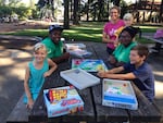 Shatoya Mills and Daylen Lawrence work with the summer meals program, where Carie Weisenbach-Folz and her three kids, Cody, Ada, and Linus Folz come for food and activities.