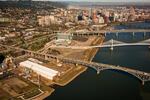 Zidell Yards spreads beneath the Ross Island Bridge between the Tillikum Crossing and OHSU.