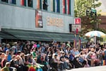 Attendees sit outside Embers Avenue for the 2016 Portland Pride parade.