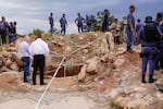 Police officers and private security personnel stand by the opening of a reformed gold mineshaft where illegal miners are trapped in Stilfontein, South Africa, Nov. 15.