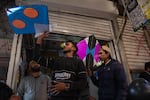 Vendors hold colorful kites in a market area near Mochi Gate ahead of the springtime festival Basant in Lahore, Pakistan. A QR code is visible on one kite, designating that the vendor was registered with the government and allowed to sell. 
