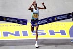 Hellen Obiri, of Kenya, raises her arms as she wins the women's division at the Boston Marathon, Monday, April 15, 2024, in Boston.