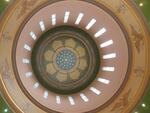 Light enters narrow windows surrounding a floral motif on the ceiling of the Oregon Capitol building.