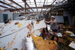 In the aftermath of Hurricane Ida, Amy Voisin cleans up the heavily damaged Bowl South of Louisiana Tuesday, Aug. 31, 2021, in Houma, La.