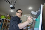 Muralist Alex Chiu paints a mural in his garage.