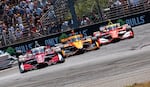 Josef Newgarden, left, Christian Lundgaard, center, and David Malukas compete through the apex of turn one, battling for the lead.