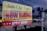 A sign seeking job applicants is seen in the window of a restaurant in Miami, Florida, on May 5, 2023.