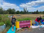 Alyssa, a Portland fourth grader, poses with a stock tank she painted this summer. She chose the design and colors.