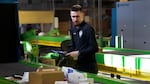 A U.S. Customs and Border Protection technician examines overseas parcels after they were scanned at the agency's overseas mail inspection facility at Chicago's O'Hare International Airport on Feb. 23, 2024.