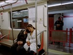 A mother and daughter rest in the women-only section of Mexico City's metro in October 2023. Police monitor the section on the platform to make sure that no men cross the barrier.