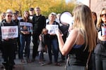 Moey Newbold speaks to people who rallied at Bend City Hall under banners of "Believe Survivors," and "Time's Up."