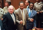 FILE - In this Oct. 3, 1995, file photo, O.J. Simpson reacts as he is found not guilty in the death of his ex-wife Nicole Brown Simpson and her friend Ron Goldman in Los Angeles. Defense attorneys F. Lee Bailey, left, and Johnnie L. Cochran Jr. stand with him. 