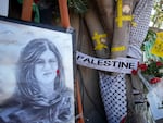 Yellow tape marks bullet holes on a tree and a portrait and flowers create a makeshift memorial on May 19, 2022, at the site where Palestinian-American Al-Jazeera journalist Shireen Abu Akleh was shot and killed in the West Bank city of Jenin.