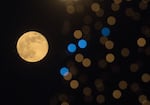 This photograph taken on December 27, 2023, shows the last full moon of the year, also known as the "Cold Moon," behind New Year's decorations in Skopje, the capital of the Republic of Macedonia.
